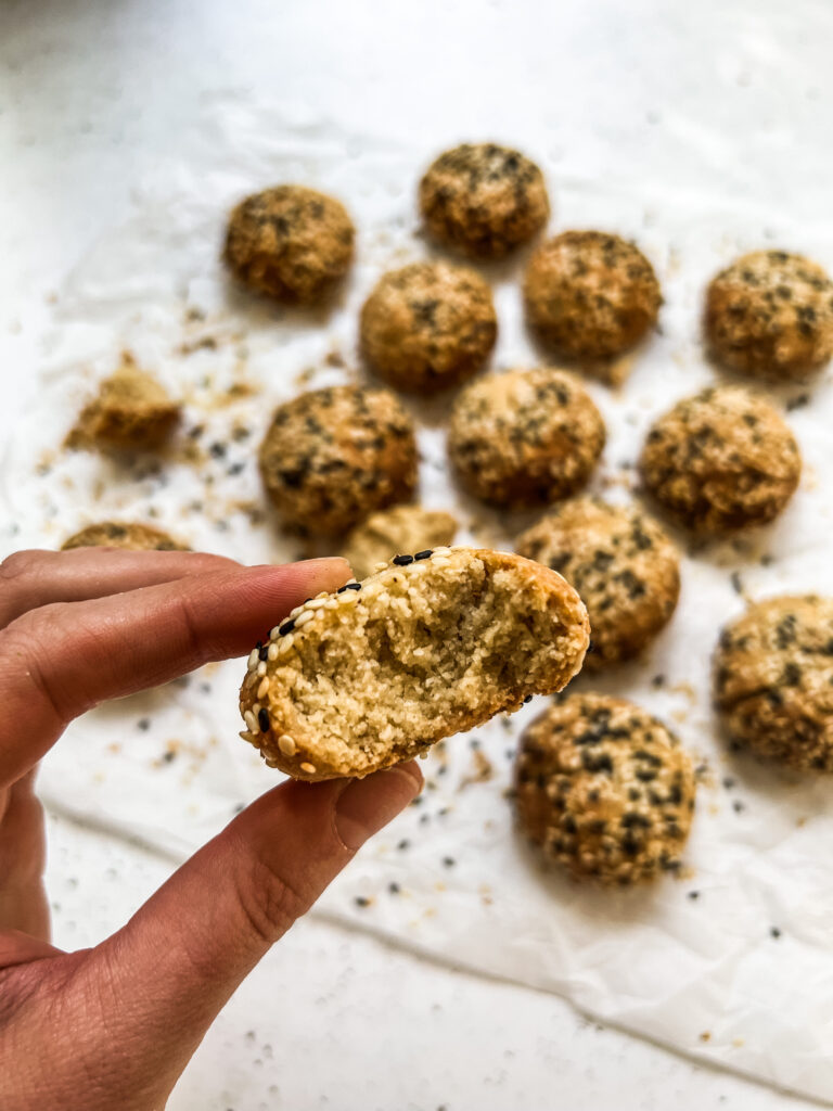 Hand holding sesame covered cookies